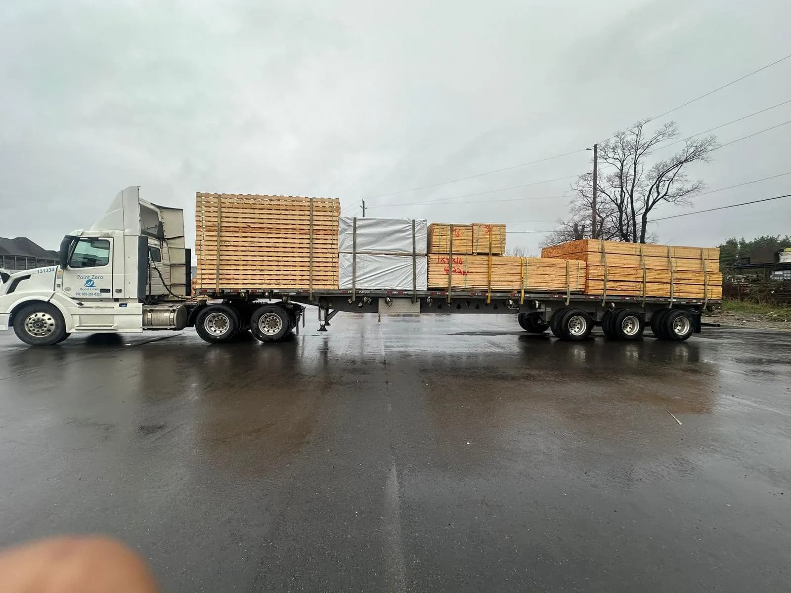 A flatbed loaded with lumber, secured for transport